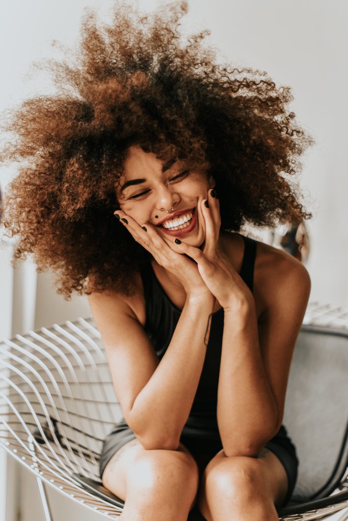 Woman of color with septum piercing smiling in mirth